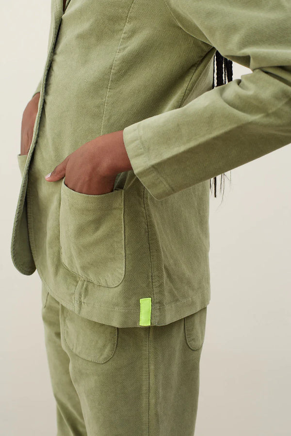 woman with hand in her pocket of green velvet khaki blazer