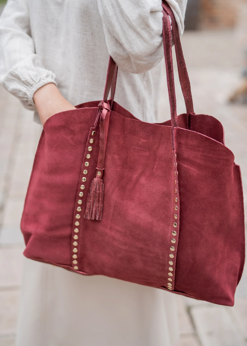 Suede tote bag with stud detail burgundy woman holding