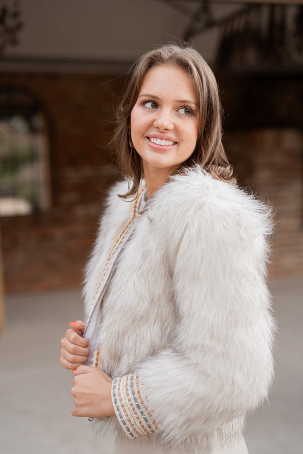 woman wearing sansom reed white faux fur statement jacket with embroidery