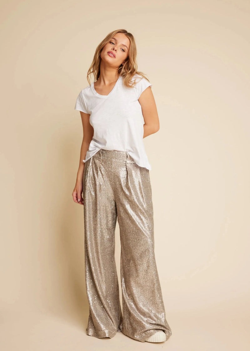 woman wearing wide leg trousers in silver sequin party trousers